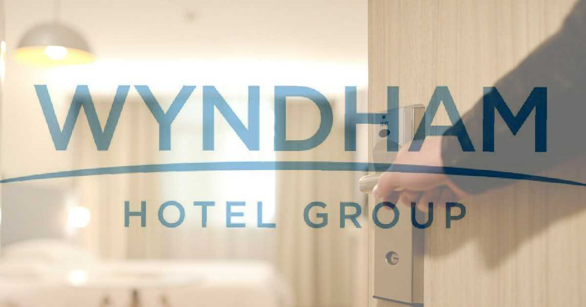 Wyndham Hotels logo imposed over the top of an image of a hotel room
