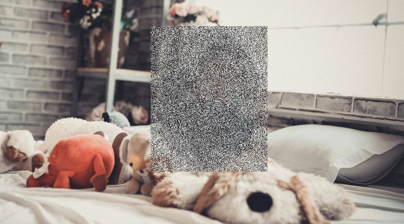 Blurred image of a young child in a bed surrounded by stuffed animals as a somber commentary on the prevalence of child sexual abuse images