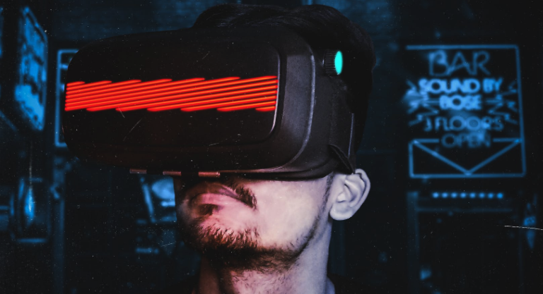 Man wears VR goggles in a dark setting