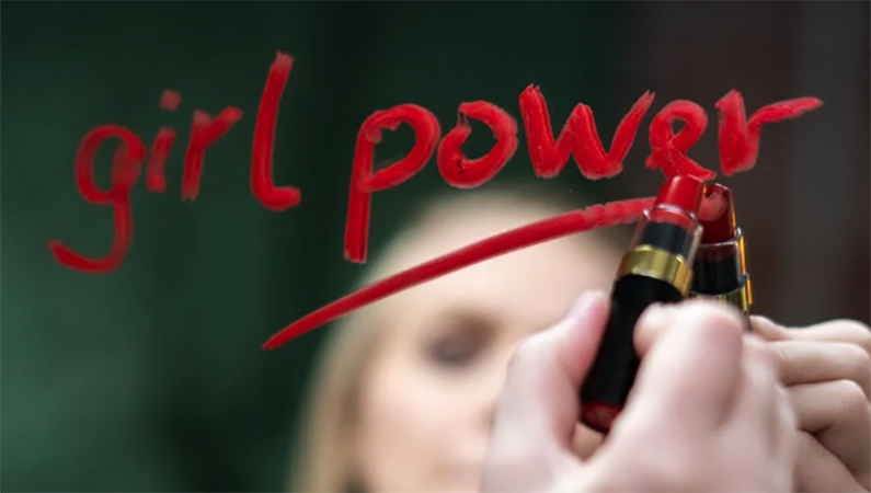 Woman writing "girl power" on a mirror with red lipstick (For NCOSE article: "No
