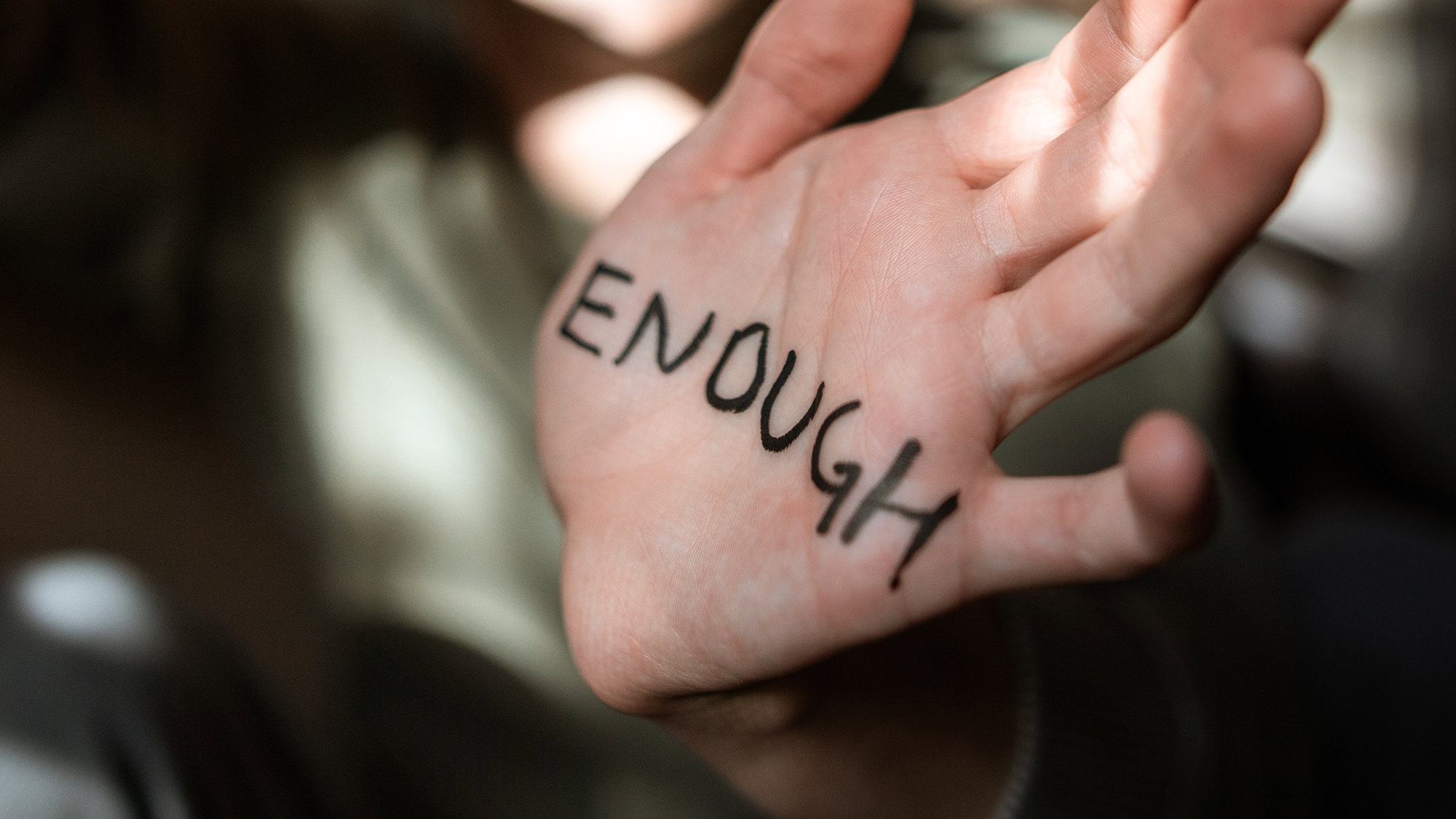 Female child's hand with "ENOUGH" written on it (for Child Sexual Abuse Awareness Month)