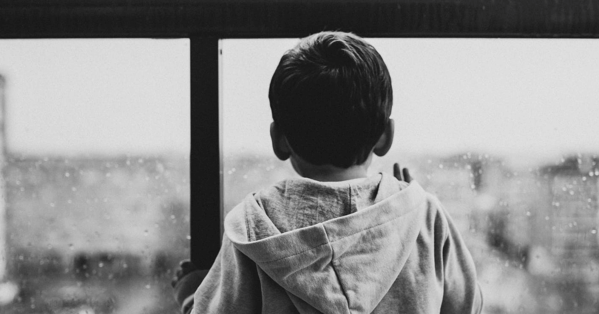 Young boy looks out rainy window (Context is an article regarding the END Network Abuse Act designed to help protect children from sexual abuse)